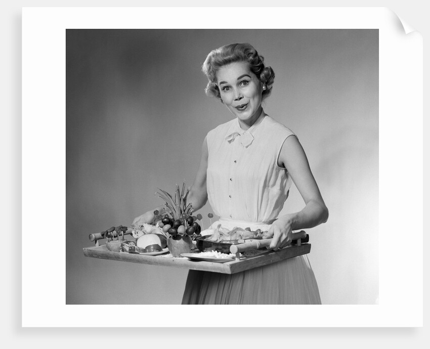 1950s woman looking at camera smiling holding platter of hors d'oeuvres snacks by Anonymous