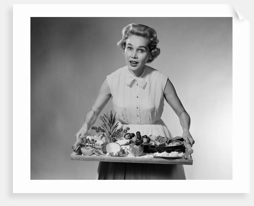 1950s woman looking at camera speaking holding platter of hors d'oeuvres snacks by Anonymous