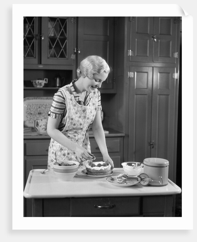 1930s woman in kitchen making strawberry shortcake by Anonymous