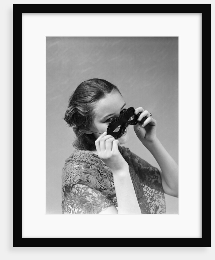 1930s 1940s woman putting on taking off black eye mask by Anonymous