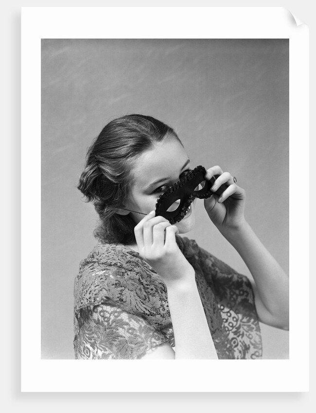 1930s 1940s woman putting on taking off black eye mask by Anonymous