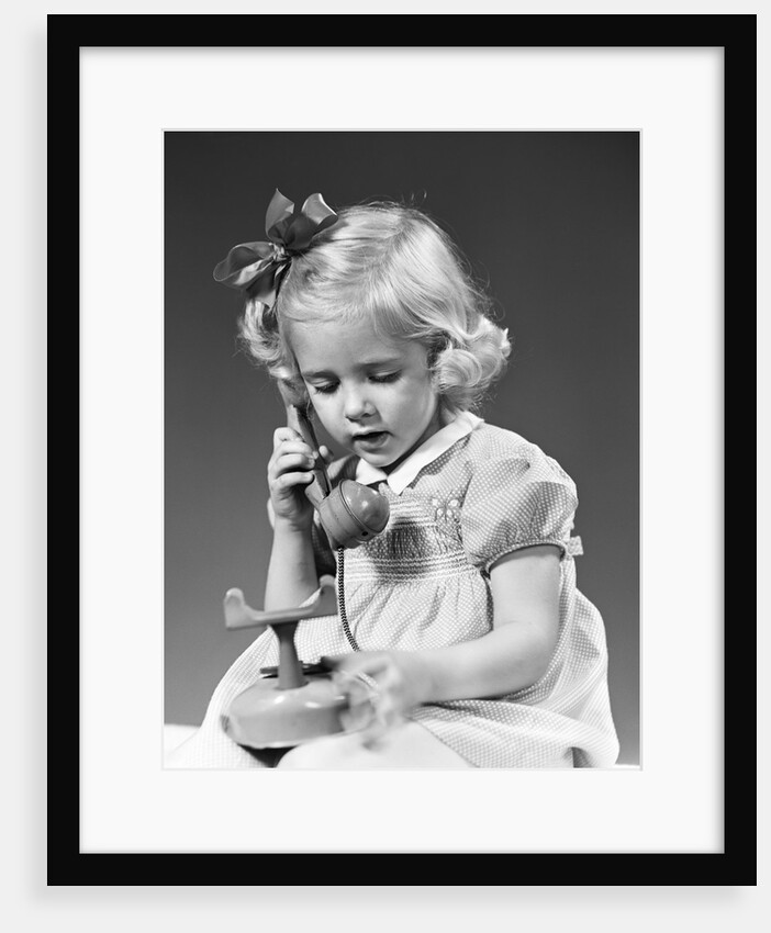 1940s little blond girl talking on toy telephone by Anonymous
