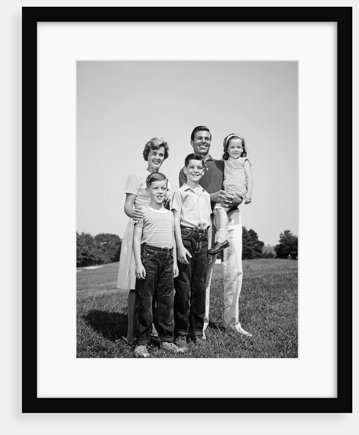 1960s smiling family portrait standing on grass mother father three children by Anonymous
