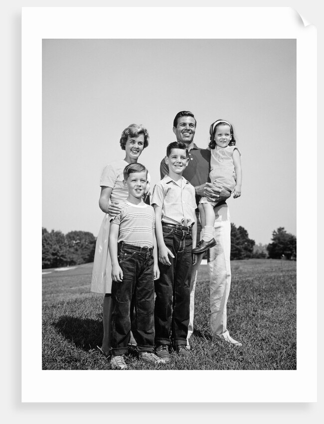 1960s smiling family portrait standing on grass mother father three children by Anonymous