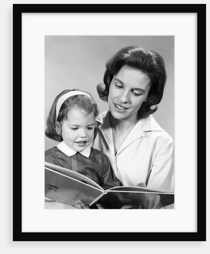 1960s woman reading story book to girl child by Anonymous