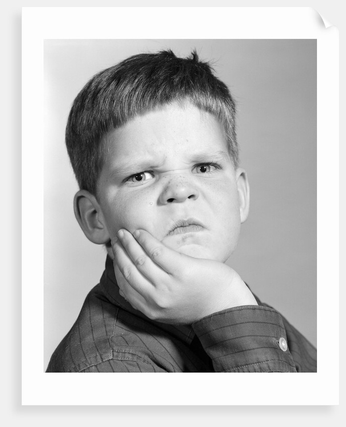 1960s little boy making angry funny facial expression looking at camera by Anonymous