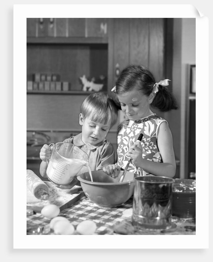 1960s two children boy girl bowl mixing pouring milk in kitchen by Anonymous