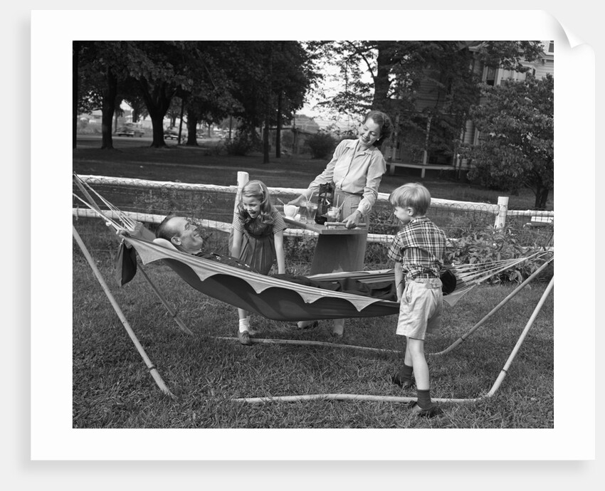 1950s mom & kids serving dad in hammock by Anonymous