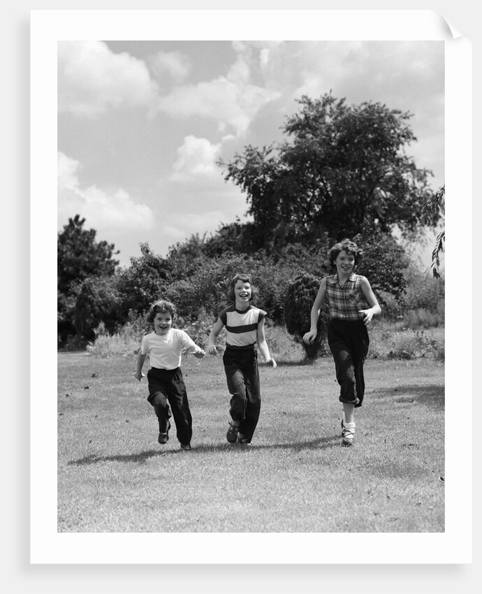 1950s three girls running in grassy field by Anonymous