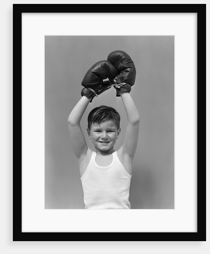 1940s boy child winner wearing boxing gloves holding hands above head looking at camera by Anonymous
