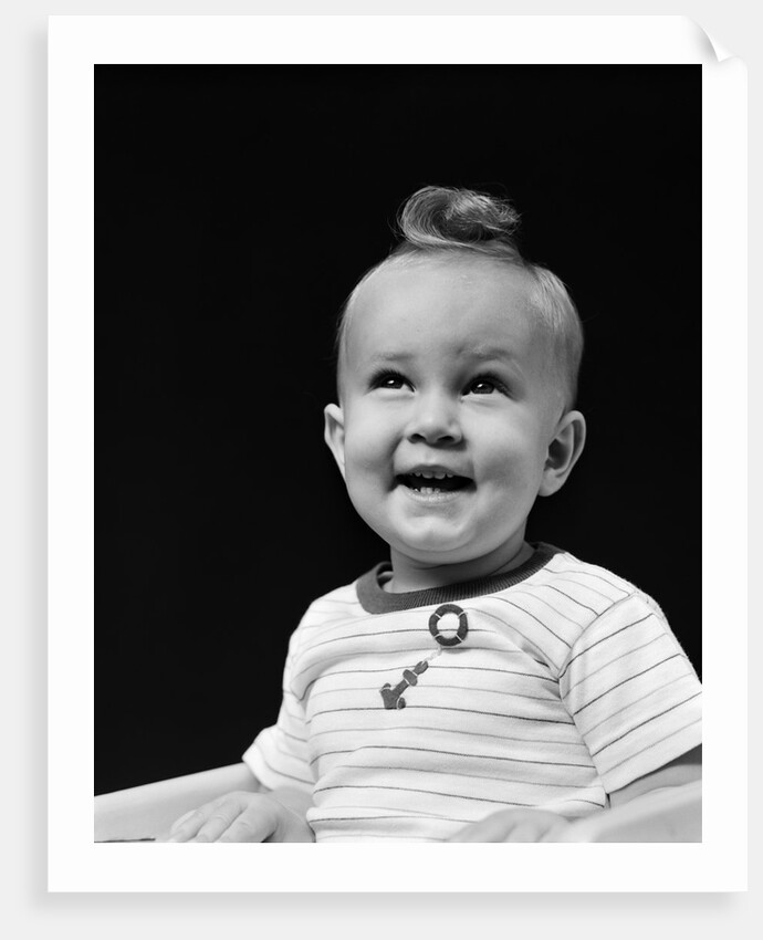 1940s smiling blond boy with big curl on top of head looking up by Anonymous
