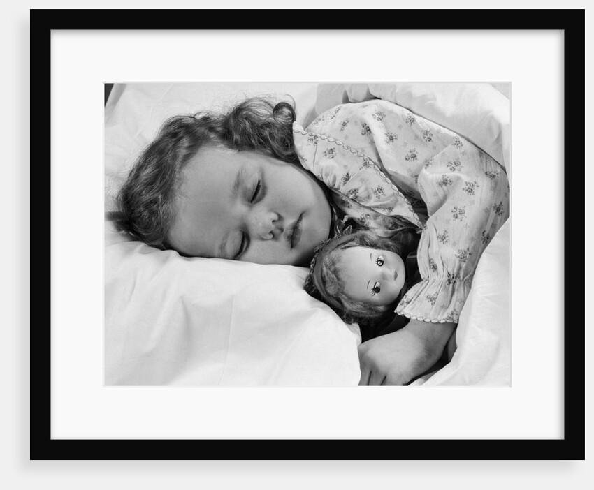 1950s child little girl sleeping in bed with doll by Anonymous