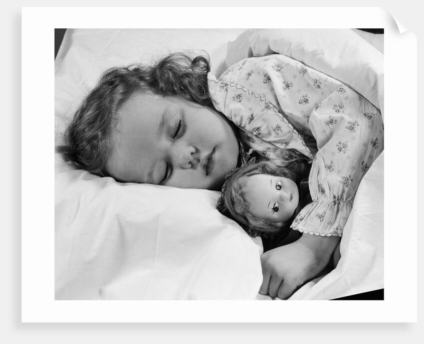 1950s child little girl sleeping in bed with doll by Anonymous