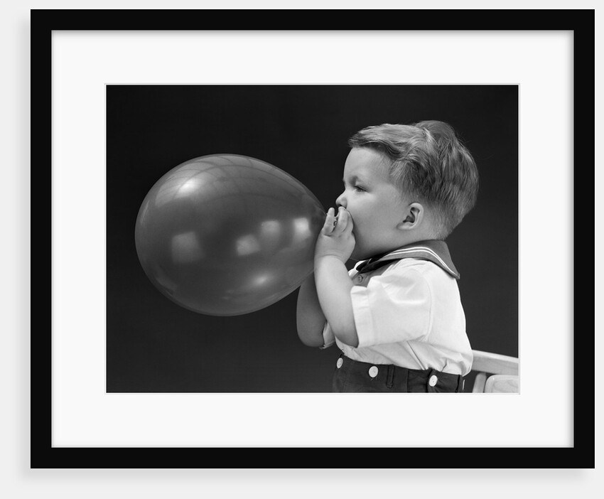 1940s boy blowing up balloon by Anonymous