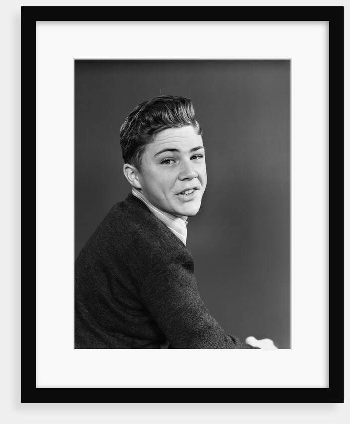 1950s portrait of smiling teenage boy looking over shoulder by Anonymous