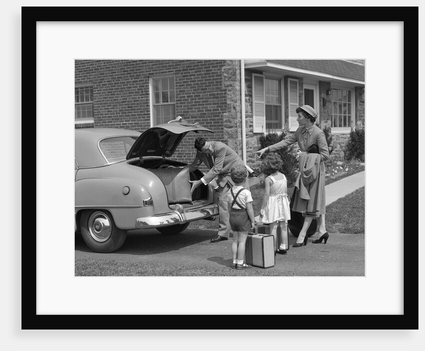1950s family putting luggage suitcases into trunk of car by Anonymous