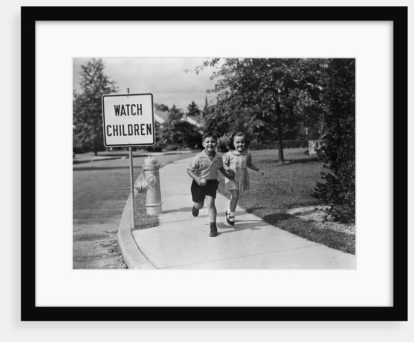 1950s children skipping walking on sidewalk watch children sign by Anonymous
