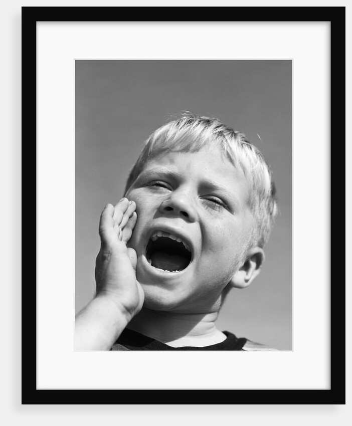 1950s blond boy with eyes closed and hand cupping a wide open mouth shouting by Anonymous
