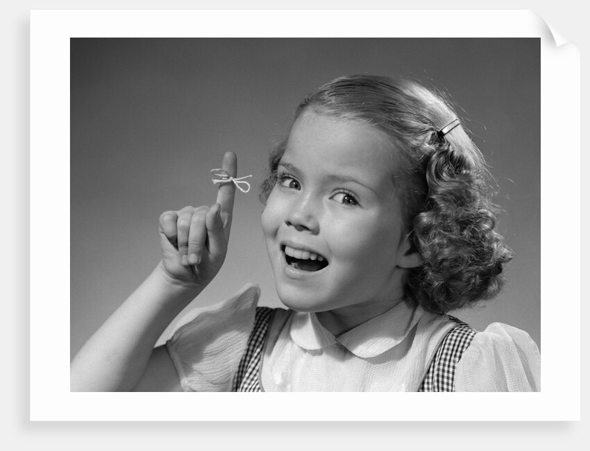 1950s little girl string tied on finger as reminder not to forget smiling looking at camera by Anonymous