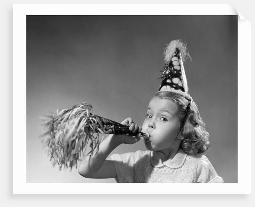 1950s girl wearing party hat blowing into noise maker looking at camera by Anonymous