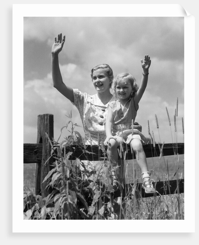1930s girl sitting on fence with woman next to her in field waving by Anonymous