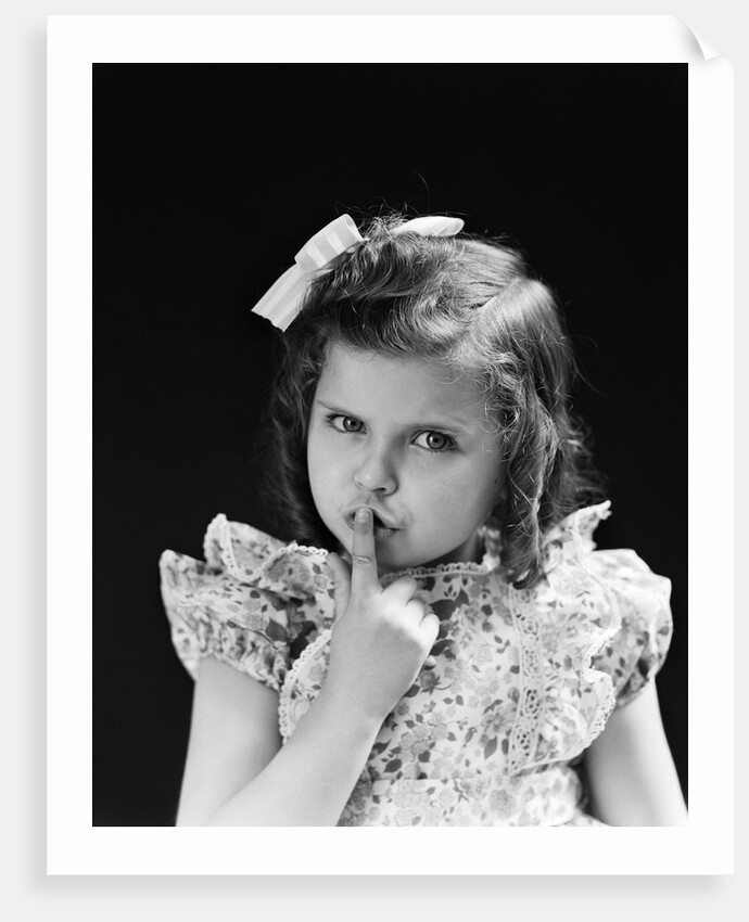 1950s child serious little girl pressing finger to lips hush be quiet secret by Anonymous