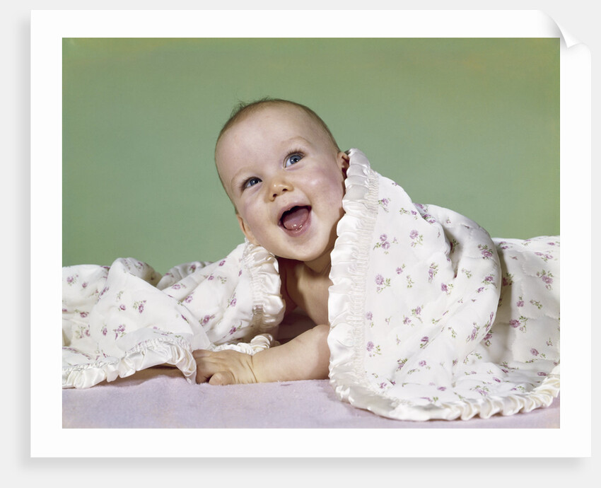 1960s smiling happy baby peeking out from under a blanket by Anonymous