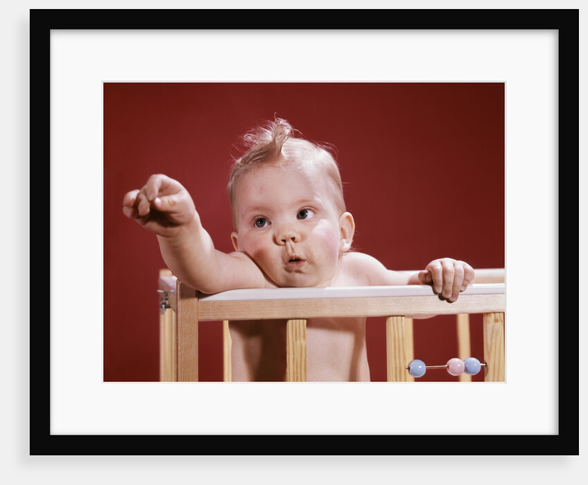 1960s baby reaching out from crib by Anonymous