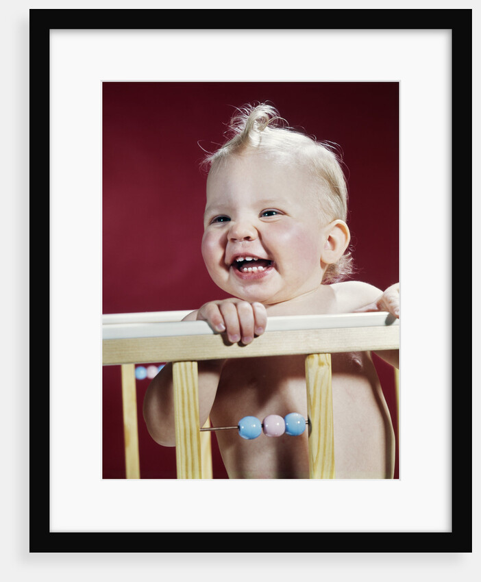 1960s laughing blond baby in crib or playpen by Anonymous