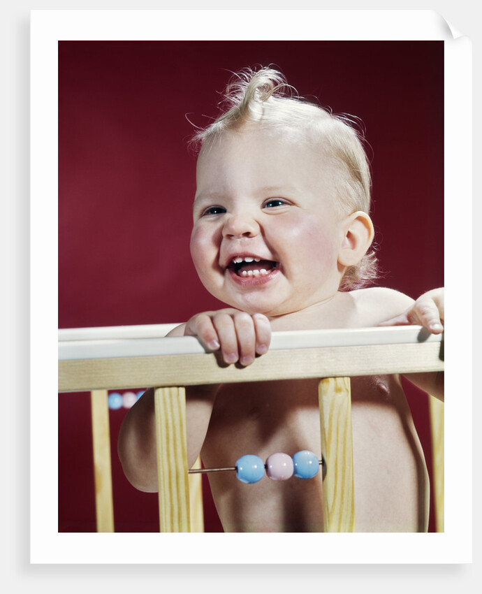 1960s laughing blond baby in crib or playpen by Anonymous