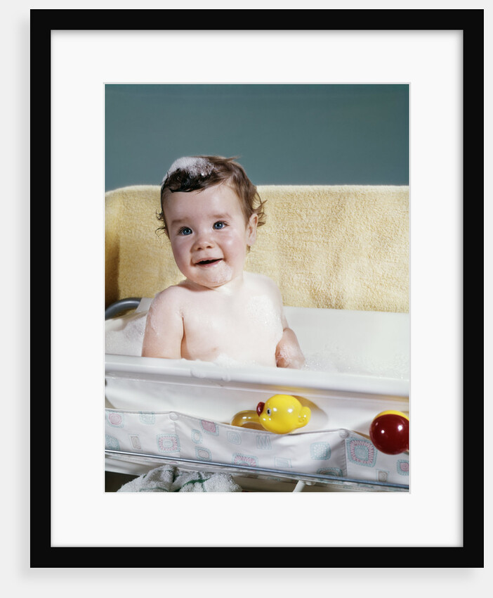 1960s smiling baby in bath looking at camera by Anonymous