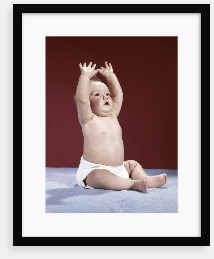 1960s baby wearing cloth diaper sitting arms raised over head by Anonymous