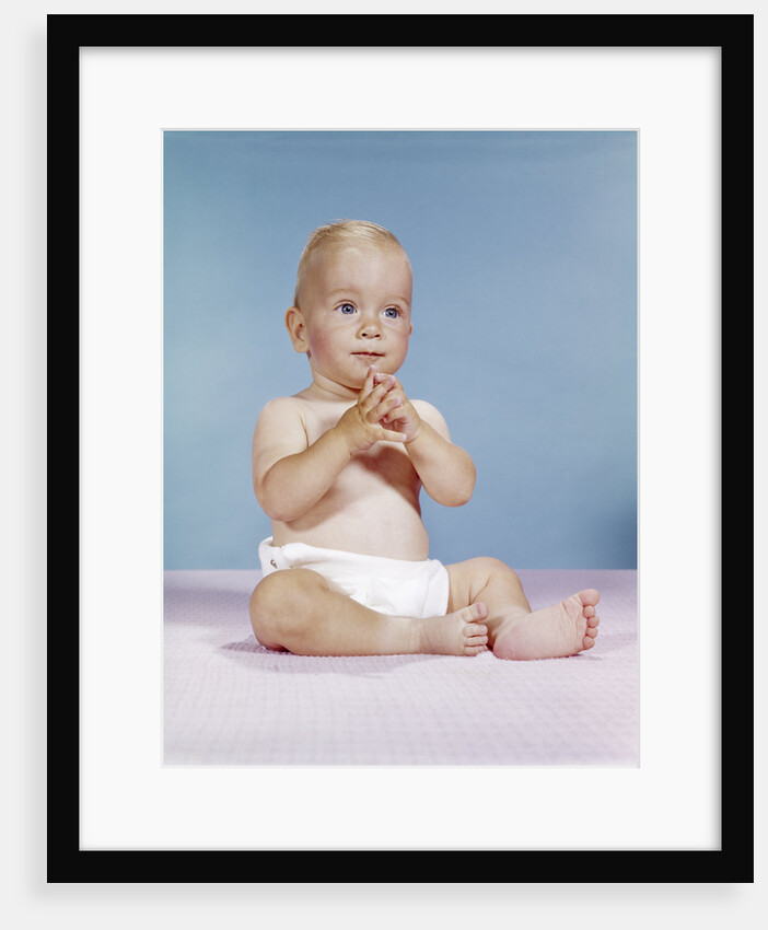 1960s baby wearing cloth diaper sitting with hands together thoughtful pose expression by Anonymous