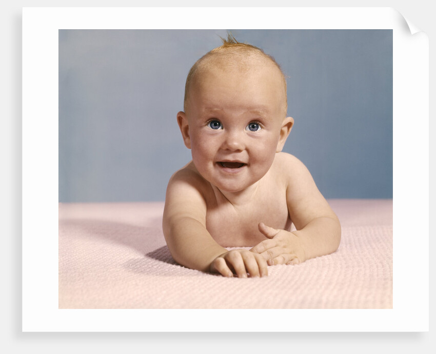 1970s smiling happy baby crawling straight ahead on pink blanket looking at camera by Anonymous