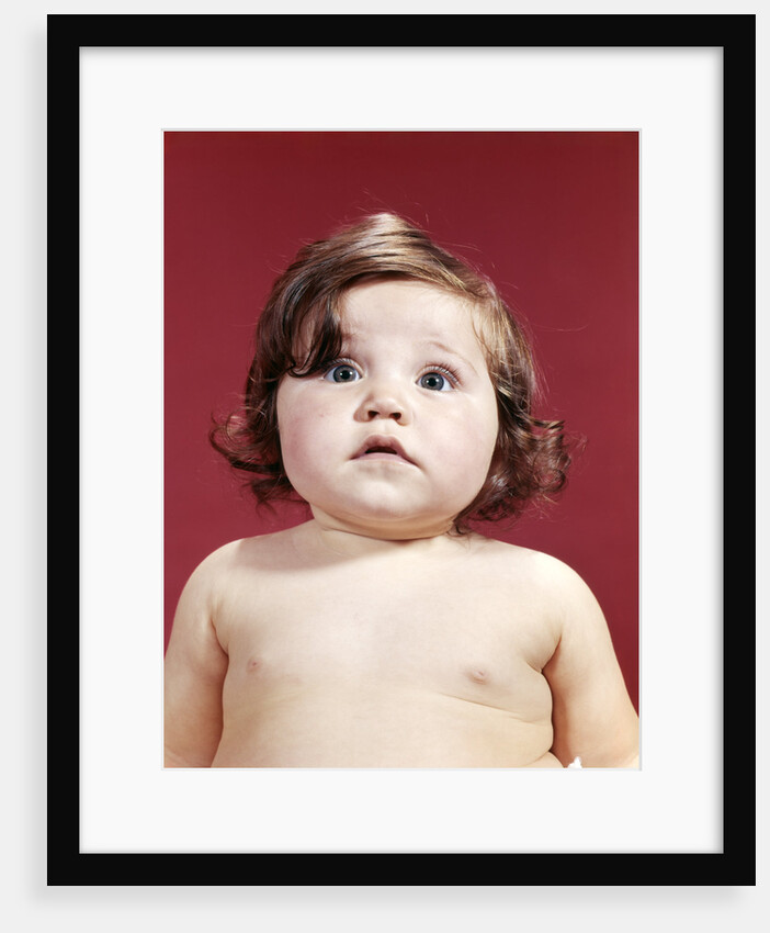 1960s portrait brunette baby girl with chubby round face uncertain facial expression looking at camera by Anonymous