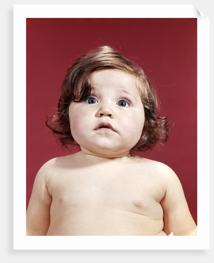 1960s portrait brunette baby girl with chubby round face uncertain facial expression looking at camera by Anonymous