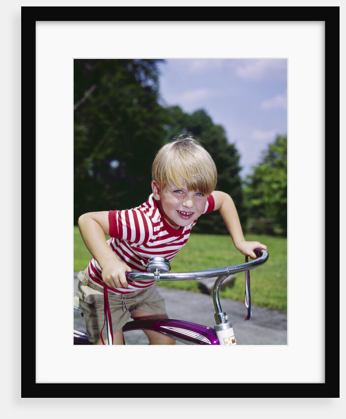 1970s 1960s smiling blond boy leaning over handlebars of bicycle looking at camera by Anonymous