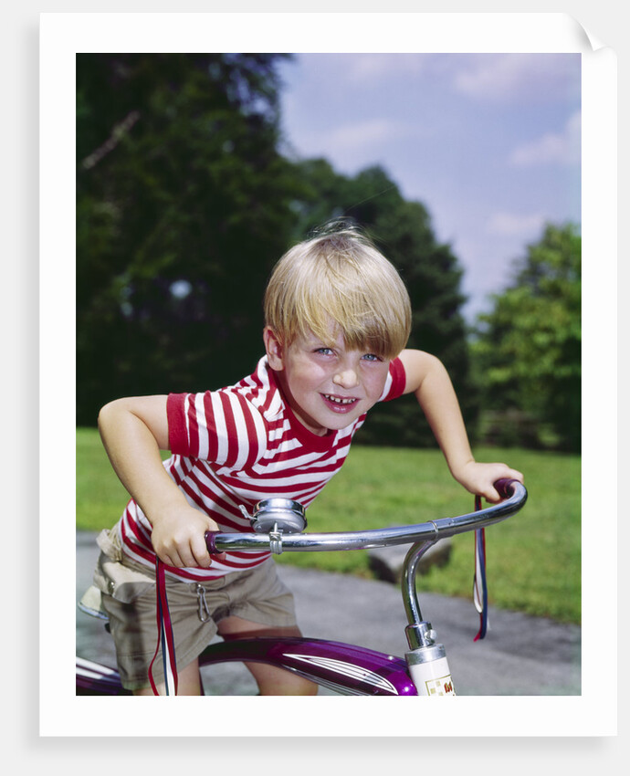 1970s 1960s smiling blond boy leaning over handlebars of bicycle looking at camera by Anonymous