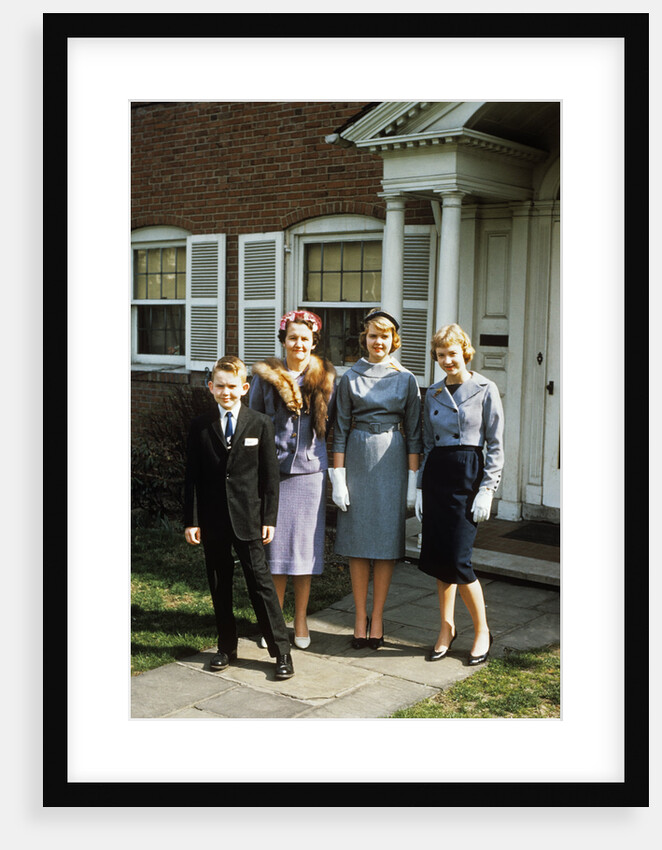 1950s mother with teenage girls & younger son dressed up posing in front of house by Anonymous