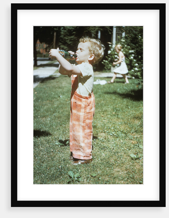 1950s little boy outside drinking soda from a 7up bottle 1951 by Anonymous