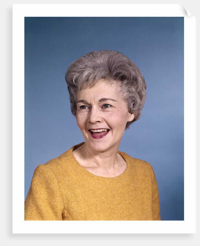1960s portrait smiling elderly woman wearing orange top laughing looking to side by Anonymous