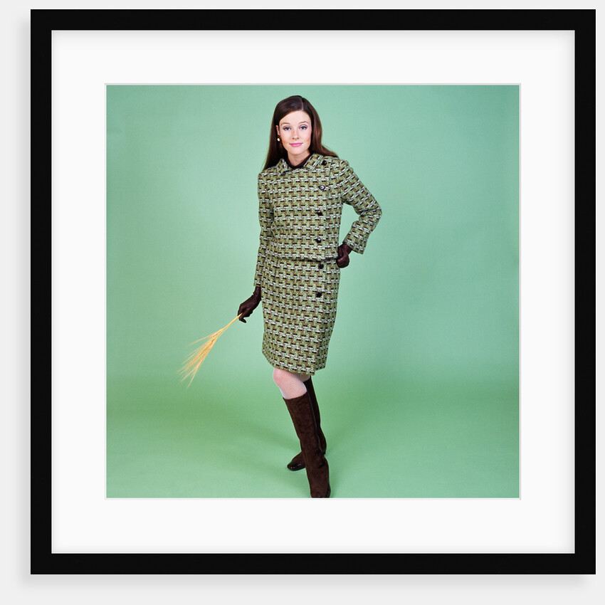 1960s young woman modeling green wool knit two piece suit fishnet stockings boots full length clothe by Anonymous