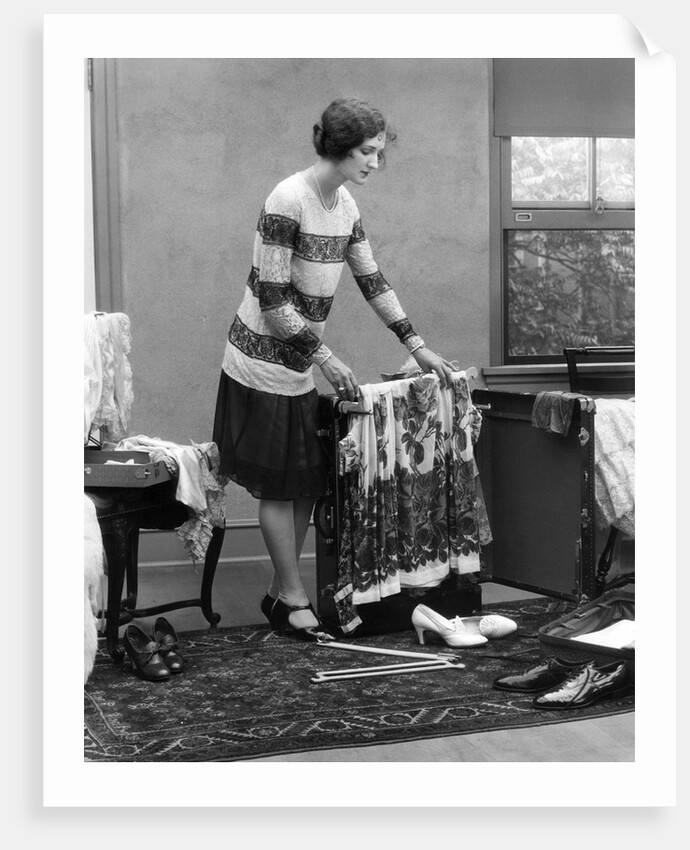 1920s woman packing clothes for travel by Anonymous