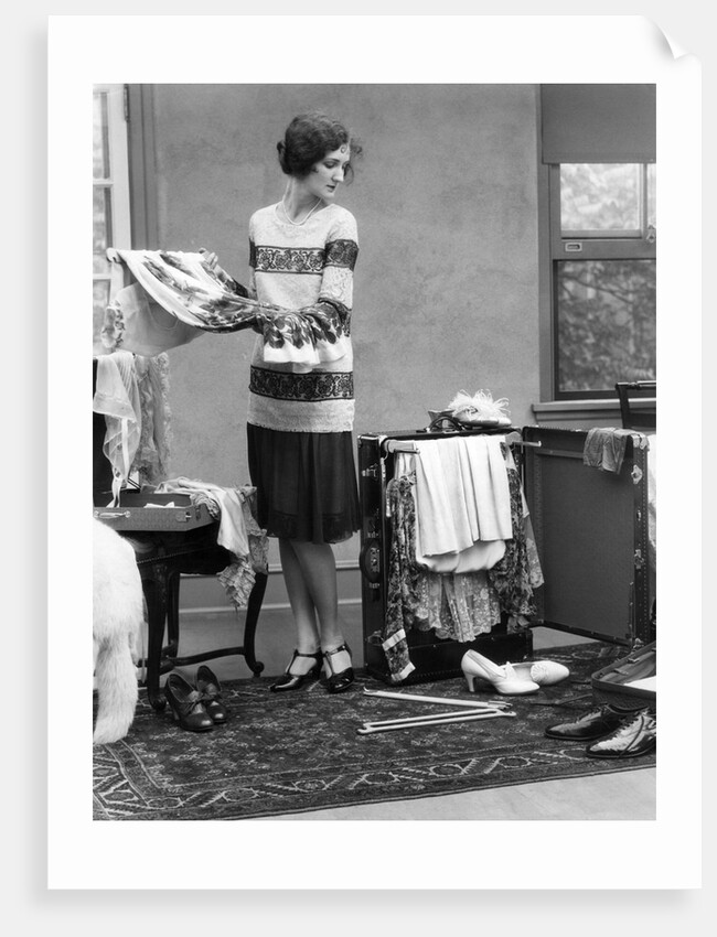 1920s woman packing clothes for travel by Anonymous