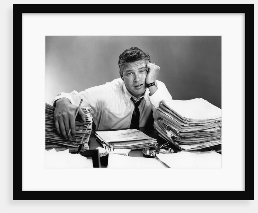 1950s portrait man overworked with desk full of papers by Anonymous