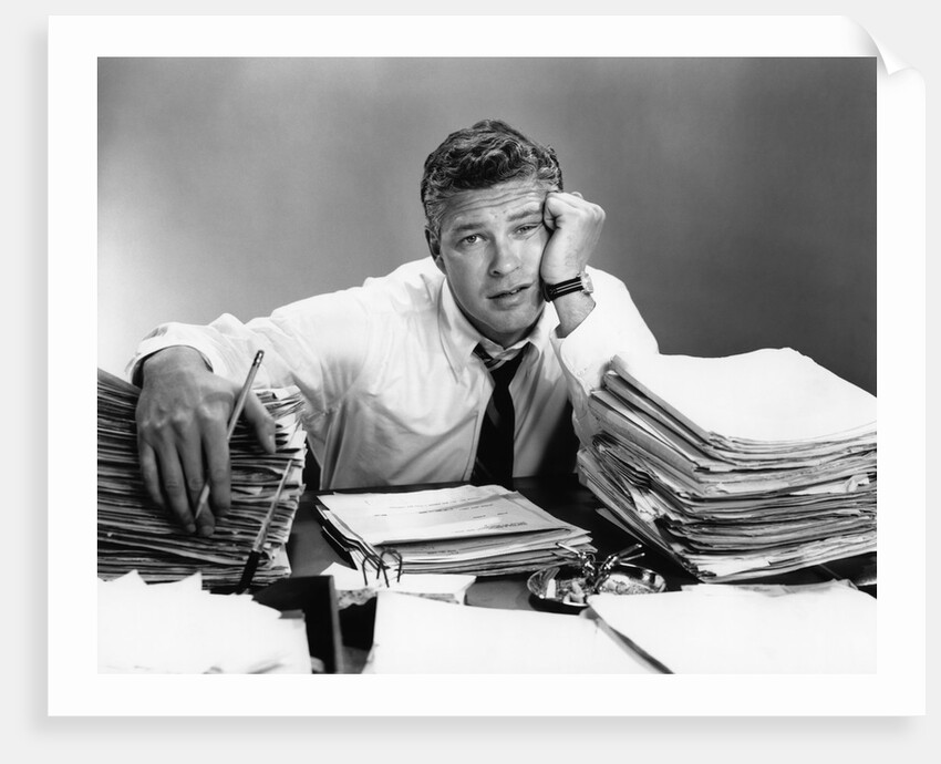 1950s portrait man overworked with desk full of papers by Anonymous