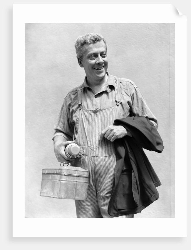 1930s man in overalls work uniform holding thermos lunchbox and jacket by Anonymous