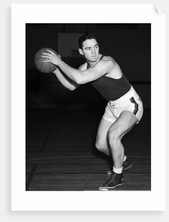 1930s teen boy playing basketball holding ball standing in position by Anonymous