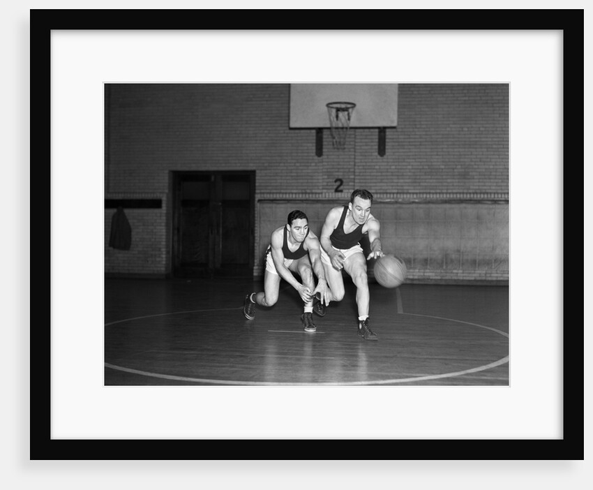 1930s two boys playing basketball inside court dribbling basketball by Anonymous