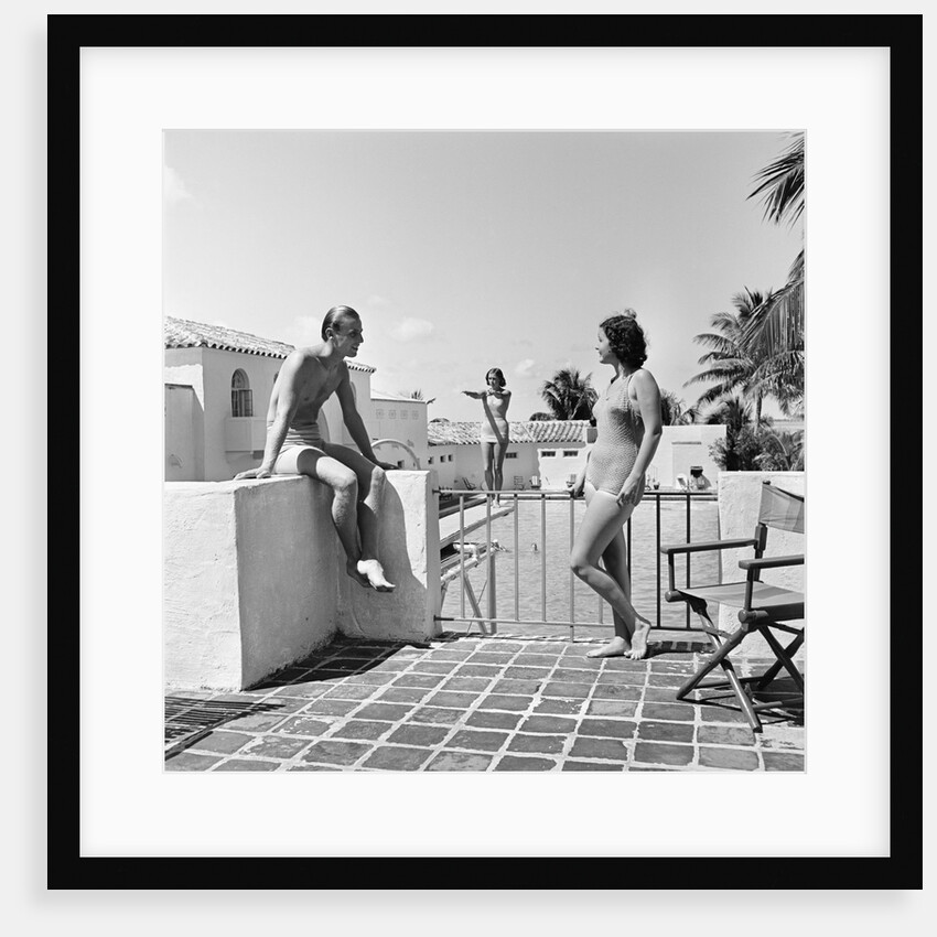 1930s man woman wearing bathing suits on terrace overlooking swimming pool woman on diving board by Anonymous